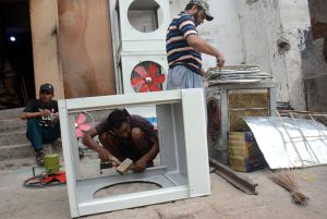 Workers assemble water air coolers to beat the intense heat, as demand surges in the city due to the scorching weather