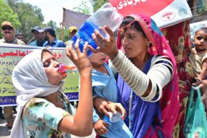 A woman gives her child summer drink at a heatstroke relief camp during hot weather in the city