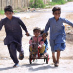 Children enjoy riding bicycle toys at Latifabad