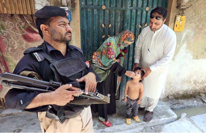 Health worker administering polio vaccine to a child during a polio campaign in the Provincial Capital