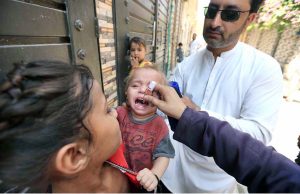 Health worker administering polio vaccine to a child during a polio campaign in the Provincial Capital