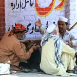 A barber busy in cutting hair of a customer at his roadside setup as the world celebrates International Labour Day. May 1st, International Workers' Day, commemorates the historic struggles of working people worldwide. In 1884, the Federation of Organized Trades and Labour Unions passed a resolution declaring that eight hours would constitute a legal day's work, effective from May 1, 1886