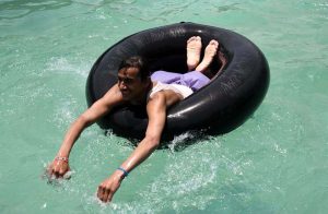 Youths dive into a swimming pool to beat the intense heat in Village Chooharpur near Larkana