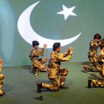 Students performing a patriotic tableau on the stage during Express Solidarity with Pakistan Armed Forces following the successful military operation Bunyanun Marsoos against Indian Aggressions