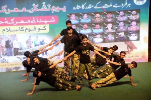 Students performing a patriotic tableau on the stage during Express Solidarity with Pakistan Armed Forces following the successful military operation Bunyanun Marsoos against Indian Aggressions