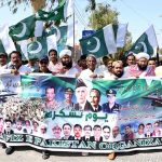 Workers of Muhafiz Pakistan Organization hold national flags as they march during a rally to express solidarity with Pakistan's armed forces at SSP Office Chowk