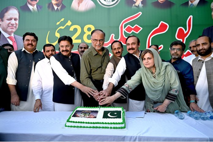Federal Minister of Planning Development & Special Initiatives, Prof. Ahsan Iqbal Chaudhary along with Federal Minister for Parliamentary Affairs Dr. Tariq Fazal Chaudhry, Parliamentary Secretary, Ministry of Federal Education and Professional Training Ms. Farah Naz Akbar and others cutting cake during an event to mark Youm e Takbeer at PML Central Secretariat, Chak Shahzad