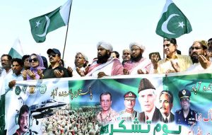 Workers of Muhafiz Pakistan Organization hold national flags as they march during a rally to express solidarity with Pakistan's armed forces at SSP Office Chowk