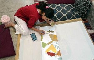 A student engages in painting and drawing activities during an art class at Alhamra Arts Council