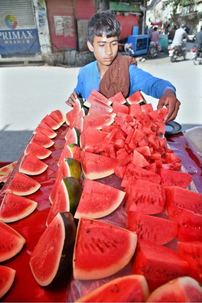 A vendor displaying watermelons to attract the customers at his roadside setup