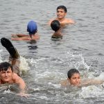 Seeking relief from the sweltering heat, children and citizens take a refreshing dip in the Arabian Sea near Native Jetty Bridge