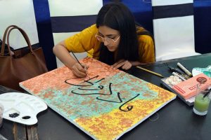 A student engages in painting and drawing activities during an art class at Alhamra Arts Council