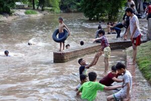 Youngsters enjoying while bathing in water pound to get relief from hot weather in the city