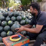 A vendor displays watermelons, a best source of hydration in the extreme heat, to attract customers in the provincial capital