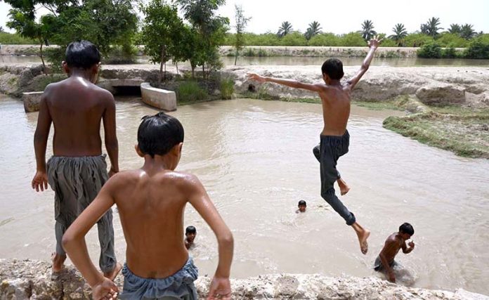 Youngsters jumping in a Canal to get some relief from scorching hot weather in the City