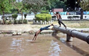 Youngsters enjoying while bathing in water pound to get relief from hot weather in the city