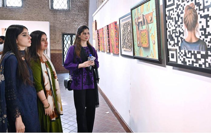 Visitor girls observe and admire a masterpiece of art on display at the NCA Art Gallery, Anarkali