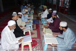People are reciting verses of the Holy Quran during a Quran Khawani sitting organized in a local Masjid to celebrate Youm-e-Tashakur