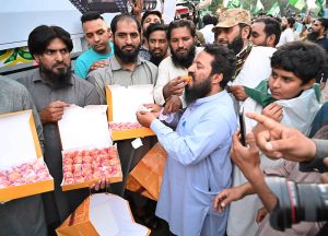 Civil society members distributing sweets to express happiness and solidarity with Pakistan Army at Mall Road Charing Cross, on the brilliant success of Operation Bunyan-un-Marsus against Indian aggression.