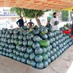 Customer purchasing water million from a roadside stall in the city
