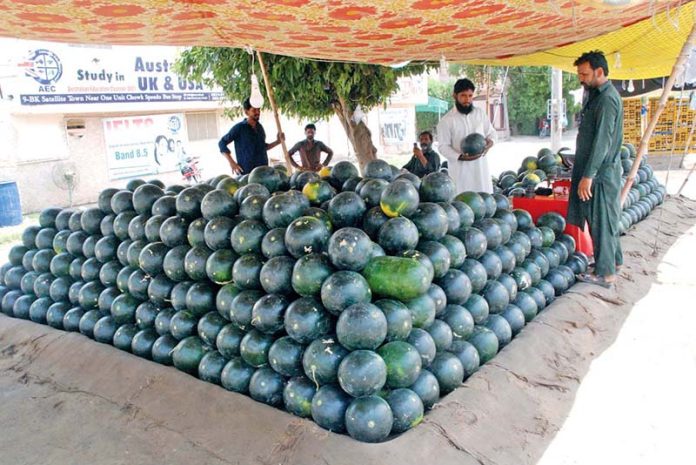 Customer purchasing water million from a roadside stall in the city
