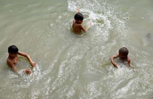 Youngsters bathing in Rice Canal to get relief from sizzling hot weather in the city