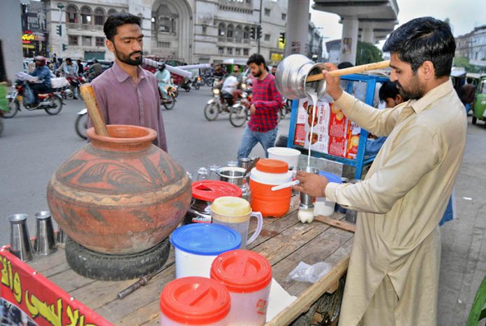 A roadside vendor making traditional drink buttermilk (Lassi) to attract the customer at Lakshmi Chowk
