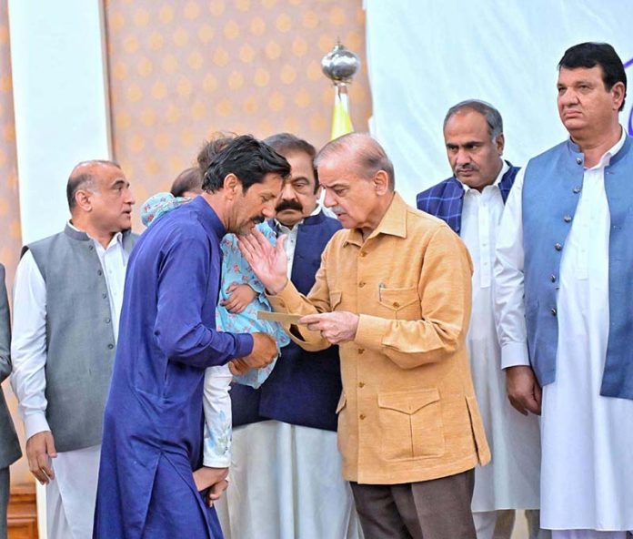 Prime Minister Muhammad Shehbaz Sharif distributing relief cheques amongst the families of martyred during Ma’arka-e-Haq