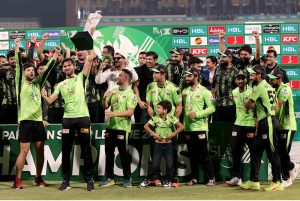 Lahore Qalandars players pose for a group photo as their captain, Shaheen Shah Afridi, lifts the trophy after winning the PSL-X T20 Final against Quetta Gladiators at Gaddafi Stadium..