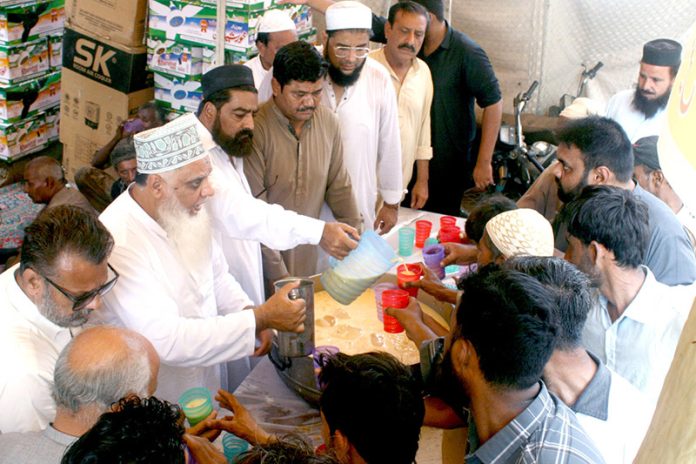 Businessman community serving free mango juice during the extreme hot weather and heat wave in city