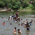 A large number of youngsters enjoy bathing in Rawal Lake spillway water to get some relief from hot weather in the Federal Capital