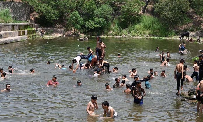 A large number of youngsters enjoy bathing in Rawal Lake spillway water to get some relief from hot weather in the Federal Capital