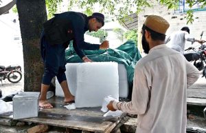 A vendor selling ice at his roadside setup at Aabpara as demand increased.