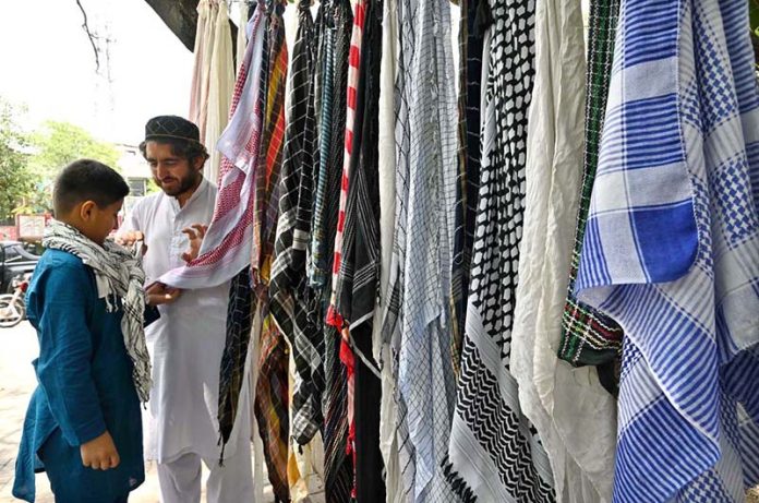A vendor sells mufflers at his roadside setup in Aabpara, the Federal Capital