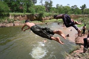A large number of youngsters enjoy bathing in Rawal Lake spillway water to get some relief from hot weather in the Federal Capital