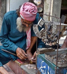 A vendor sells mufflers at his roadside setup in Aabpara, the Federal Capital