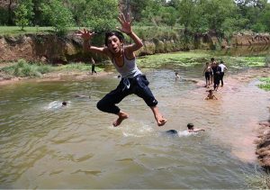 A large number of youngsters enjoy bathing in Rawal Lake spillway water to get some relief from hot weather in the Federal Capital