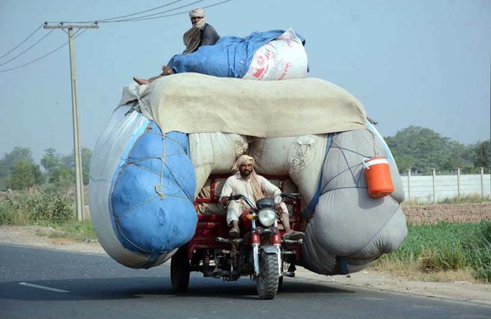An overloaded motorcycle rickshaw on the way violating the traffic rules and creating hurdles for smooth traffic flow