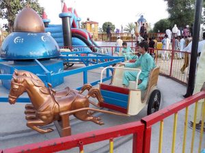 Visitors enjoy swing on merry-go round on 3rd day of Eid Ul Azha celebrations at River Chenab Park