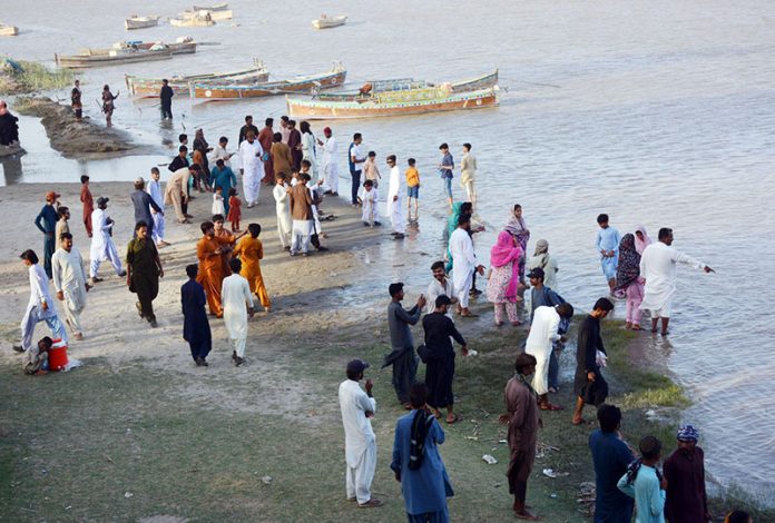 Families enjoy a refreshing break by the Indus River to beat the heat on a hot summer day