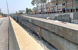 A labourer busy giving finishing touches to the wall at the under-construction underpass site in Saddar Cantt in twin cities