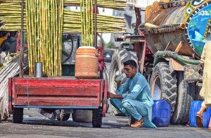 A man enjoys a glass of sugarcane juice to quench his thirst and beat the scorching heat in the federal capital