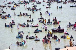 Large number of people enjoy bathing to get relief from scorching hot weather at Keenjhar Lake.
