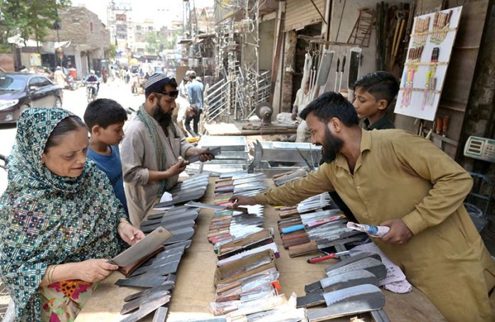 A vendor displaying knives and another items at Fort Road to be used for slaughtering sacrificial animals on the occasion of Eid-ul-Adha