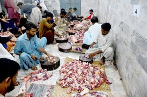 Butchers slaughtering sacrificial animal camel on the 2nd day of Eidul Azha.