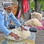 An elderly person busy preparing ‘khas’ (used in room coolers) at his roadside setup near Peshawar Morr