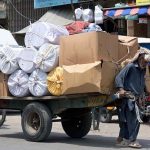 An elderly man pulls an overloaded cart with his full force through Raja Bazaar to earn a livelihood for his family under burning sun as temperatures soar in the city