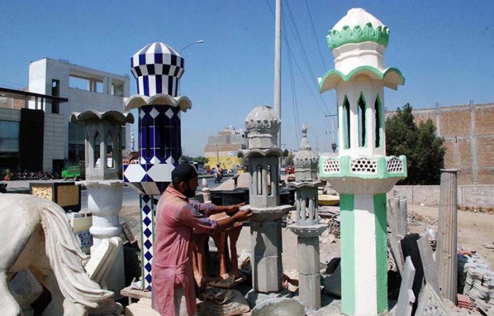 An artist busy in making minaret of mosque at a factory in the city