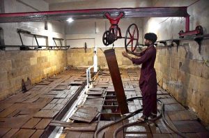 A worker removes an ice block from the ice box after preparation for delivery at the local ice factory.