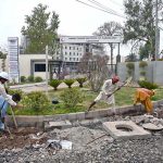 Labourers engage in construction work in front of the Nawaz Sharif Institute of Cardiology